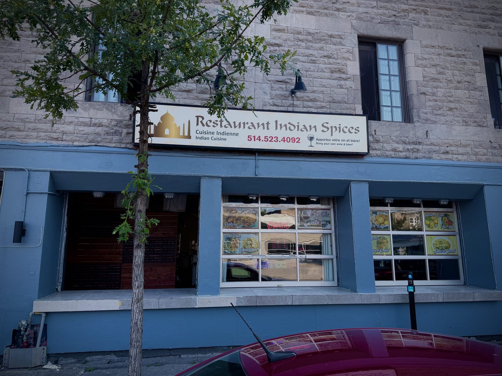 Street view of Restaurant Indian Spices at 1418 Rue Cartier — golden sign and blue facade on a greystone building